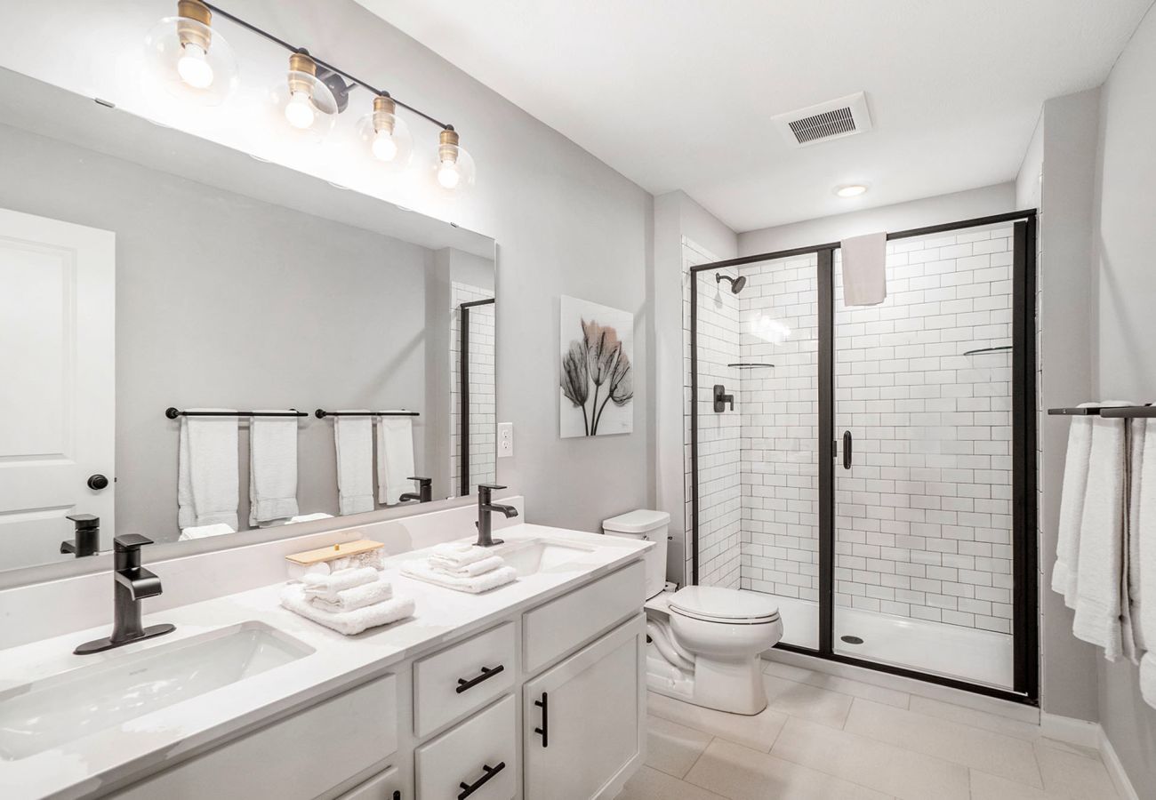 Primary bathroom with double-sink vanity and glass walk-in shower