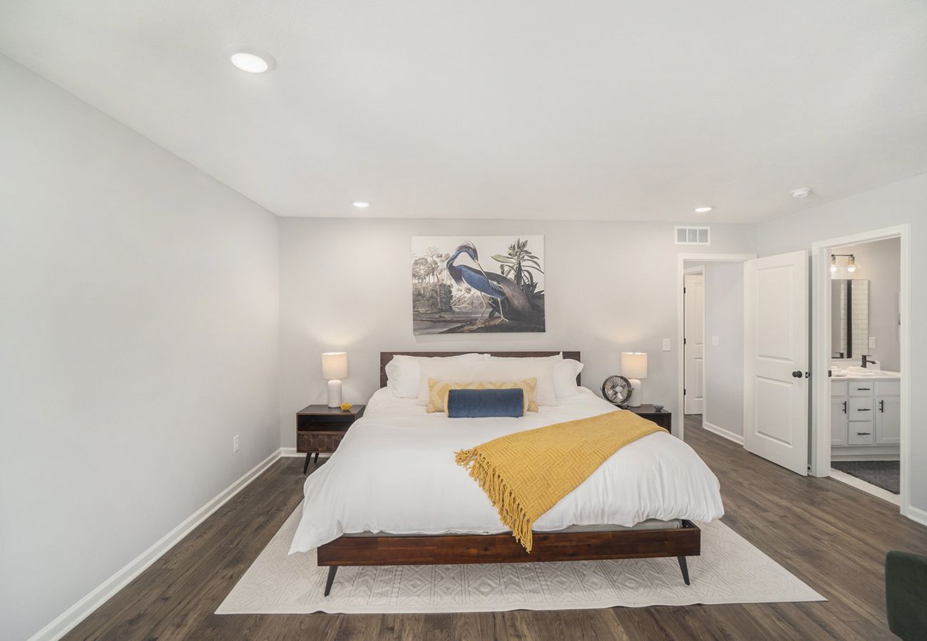 Large bedroom with king bed, modern decor, and ensuite bathroom