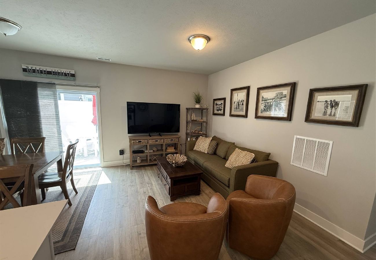 Living room with sofa, leather chairs, dining table, and patio access in South Haven, MI