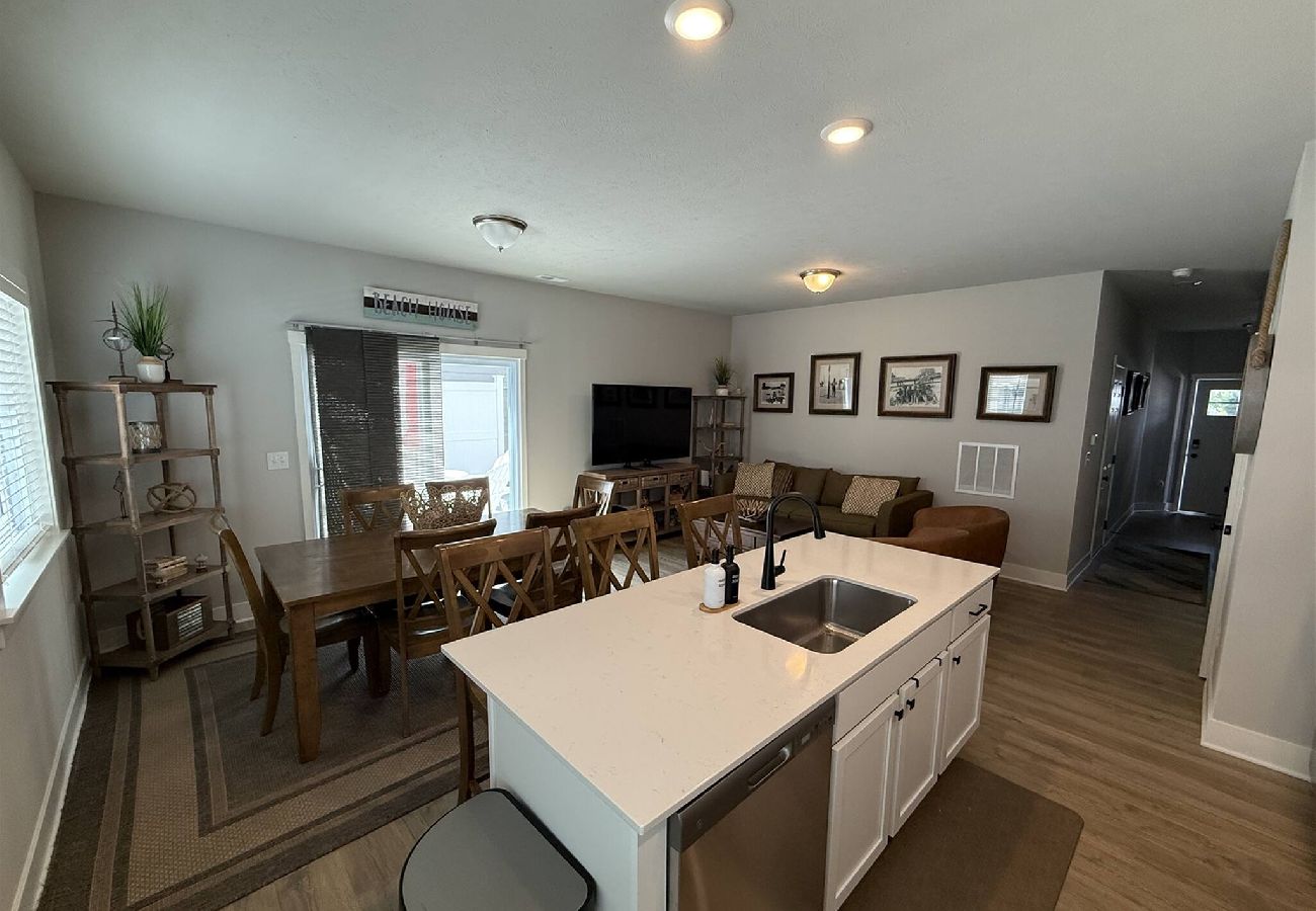 Open living area with kitchen island, dining table, and seating
