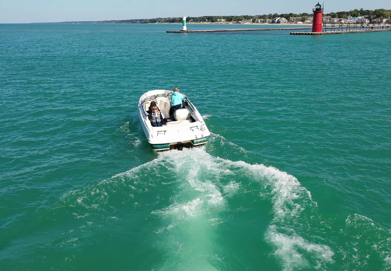 Small boat on Lake Michigan heading toward the South Haven lighthouse with turquoise water