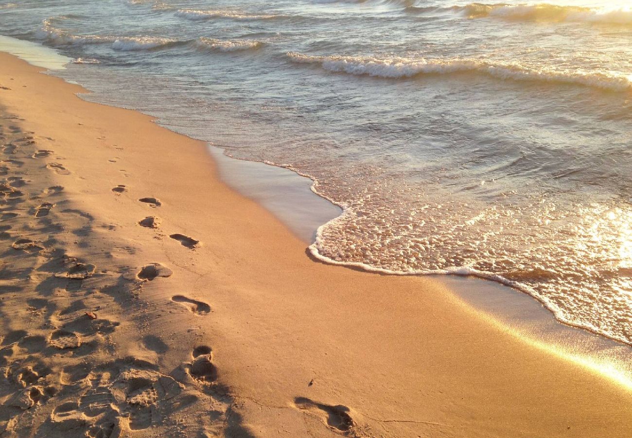 Footprints in the sand along Lake Michigan beach at sunset in South Haven MI
